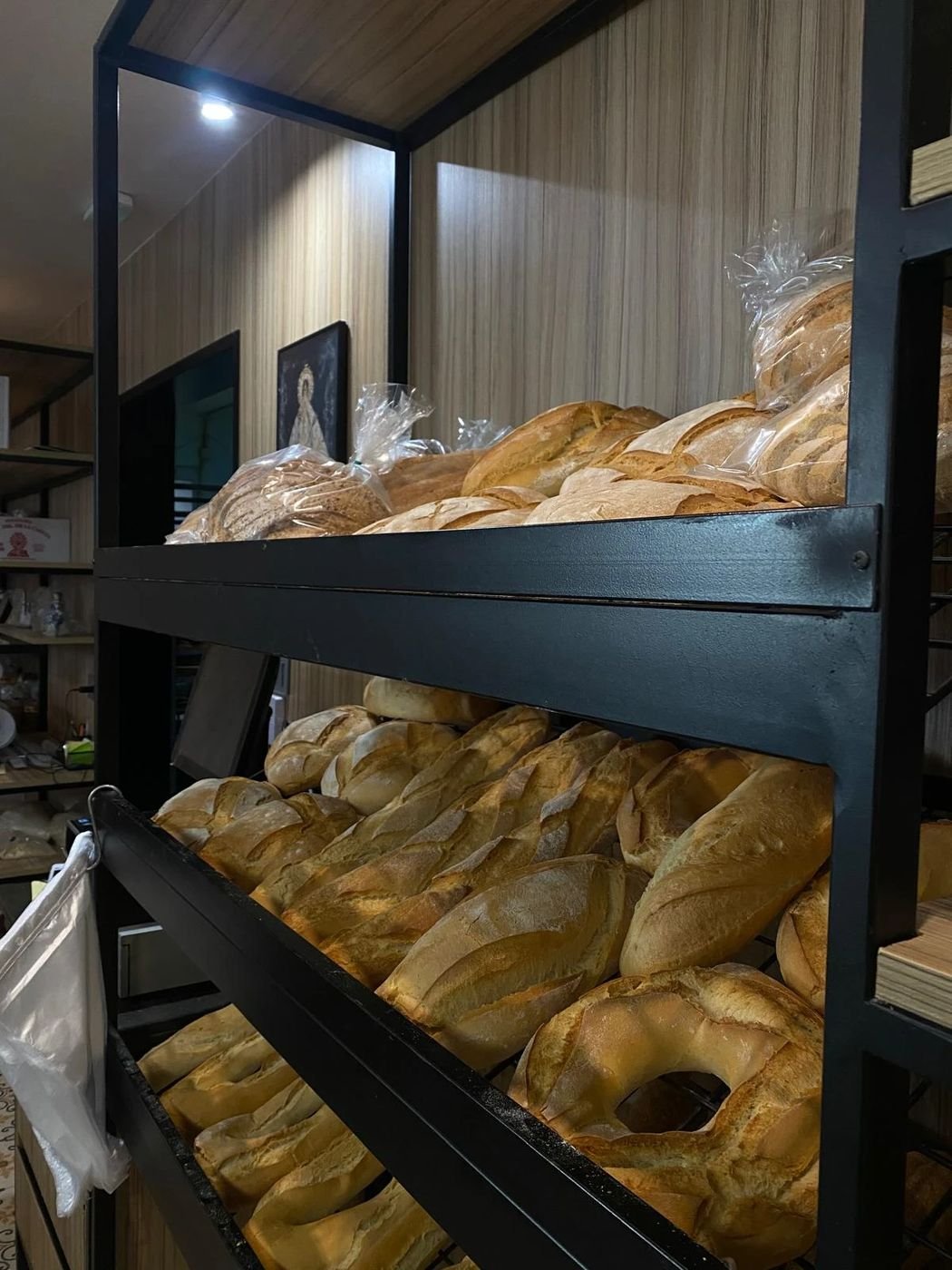 Expositor de pan de la tienda con hogazas, barras y roscos
